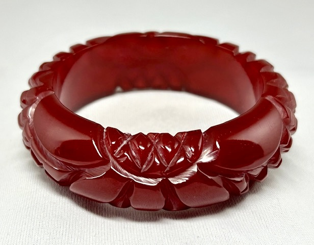 BB434 translucent cranberry flower carved bakelite bangle